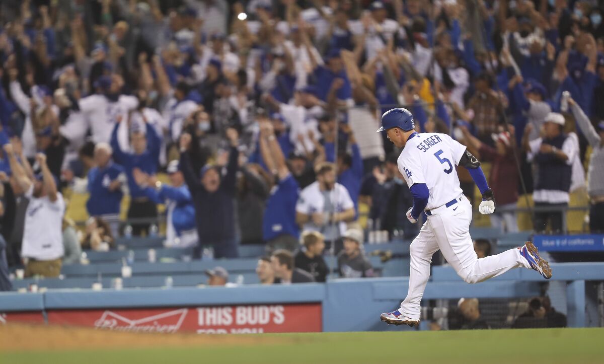 The crowd cheers as Corey Seager rounds the bases.