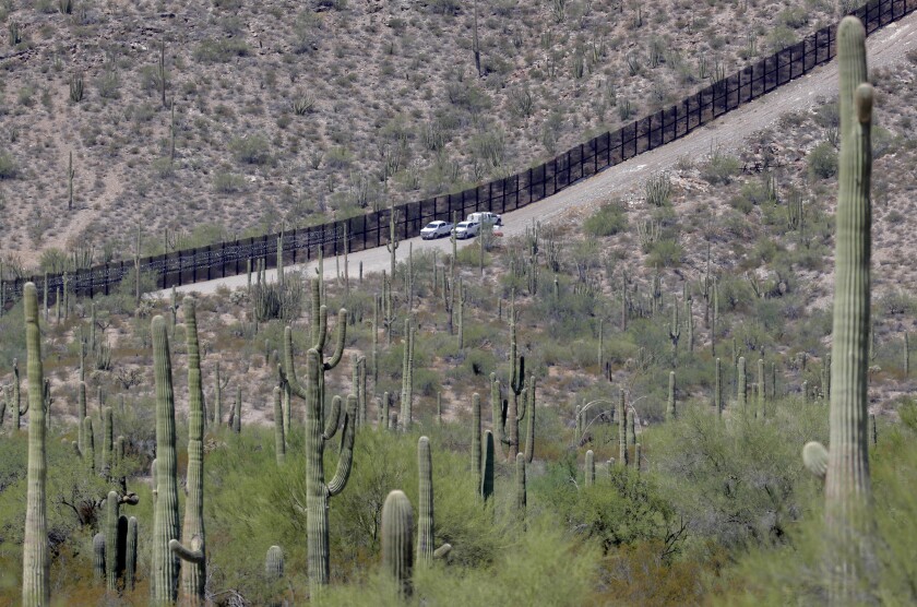 FILE - In this Aug. 22, 2019, file photo, U.S. Customs and Patrol agents sit along a section of the international border wall that runs through Organ Pipe National Monument in Lukeville, Ariz. A public-private project that maps the bodies of border crossers recovered from Arizona's inhospitable deserts, valleys and mountains said this week of Monday, Jan. 4, 2021 that it documented 227 such deaths in 2020, the highest in a decade following the hottest, driest summer in state history. (AP Photo/Matt York, File)
