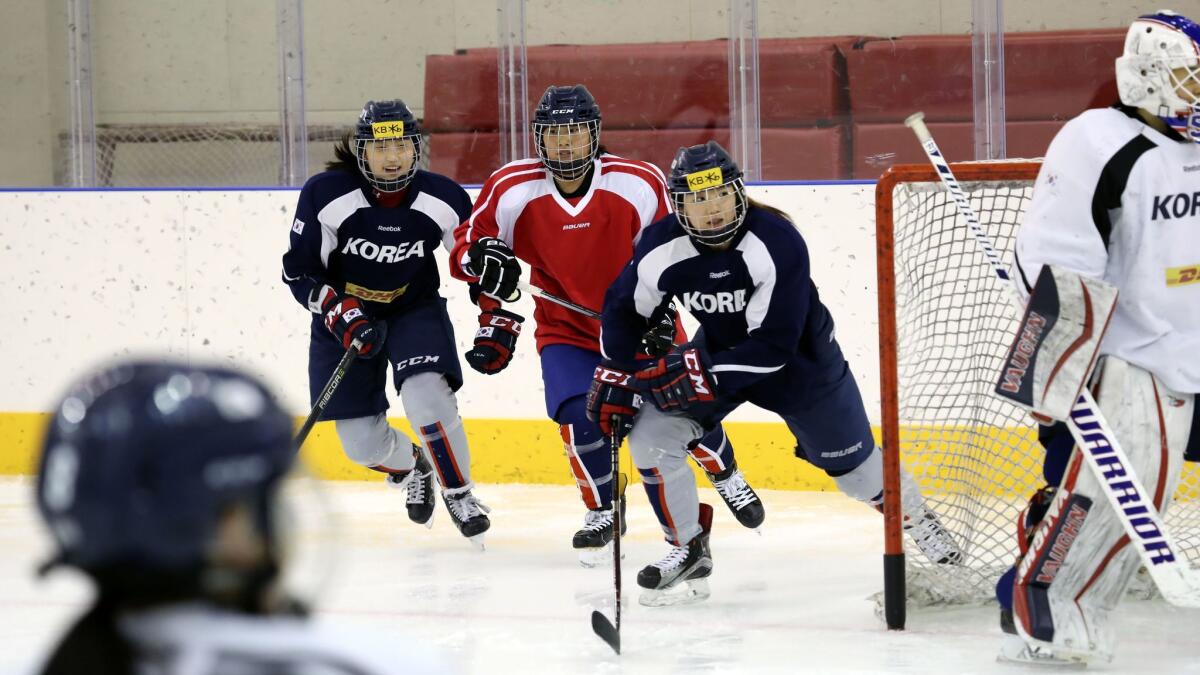 South Korean, in dark jerseys, and North Korean women's hockey team players train in Jincheon, South Korea, on Jan. 28, 2018.