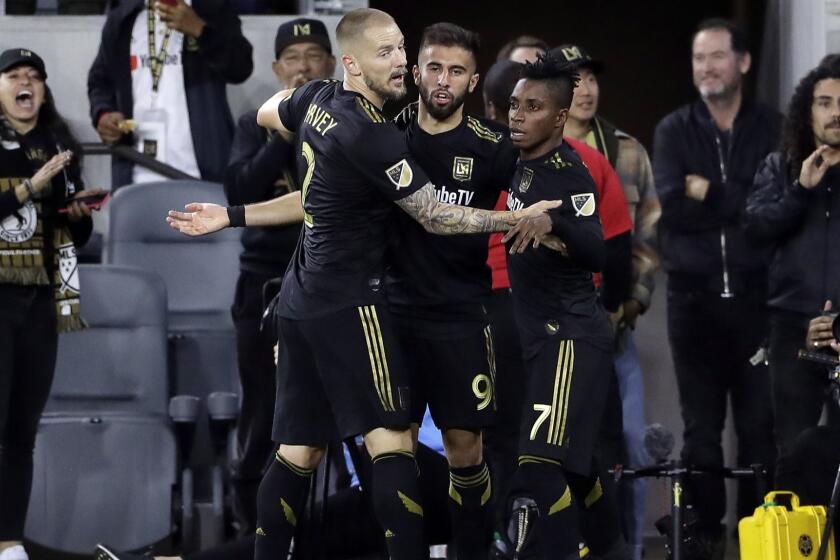 Los Angeles FC's Diego Rossi, center, is hugged by teammates Jordan Harvey, left, and Latif Blessing after Rossi's goal against Real Salt Lake during the first half of an MLS soccer match Saturday, March 23, 2019, in Los Angeles. (AP Photo/Marcio Jose Sanchez)