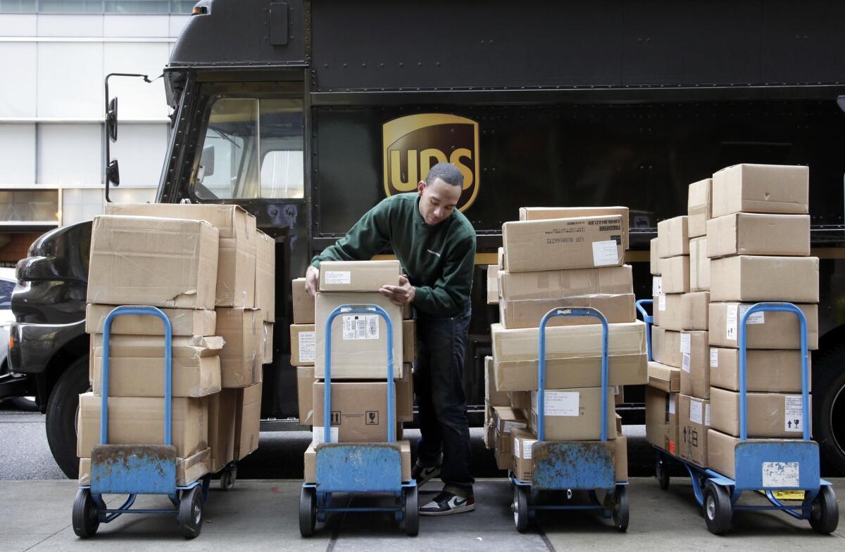 United Parcel Service said it will hire 55,000 seasonal workers for the holiday shipping season. Above, a 2011 file photo shows a driver unloading packages in New York.
