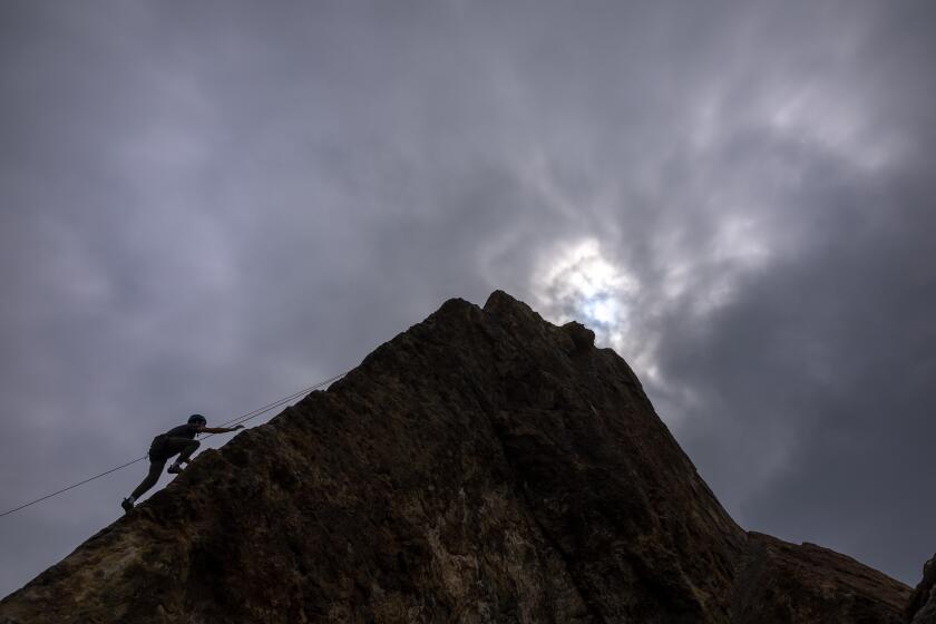 Malibu, CA - September 12: Climber Kevin Fentress, of Brooklyn. NY, climbs up the high seaside cliff at Point Dome under overcast skies on Thursday, Sept. 12, 2024 in Malibu, CA. Weather in Southern California will continue to cool over the weekend with highs in the 70s along the coast to 90 degrees inland. (Brian van der Brug / Los Angeles Times)