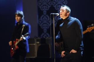 Gem Archer, left, and Liam Gallagher of British band "Oasis" perform during a television show