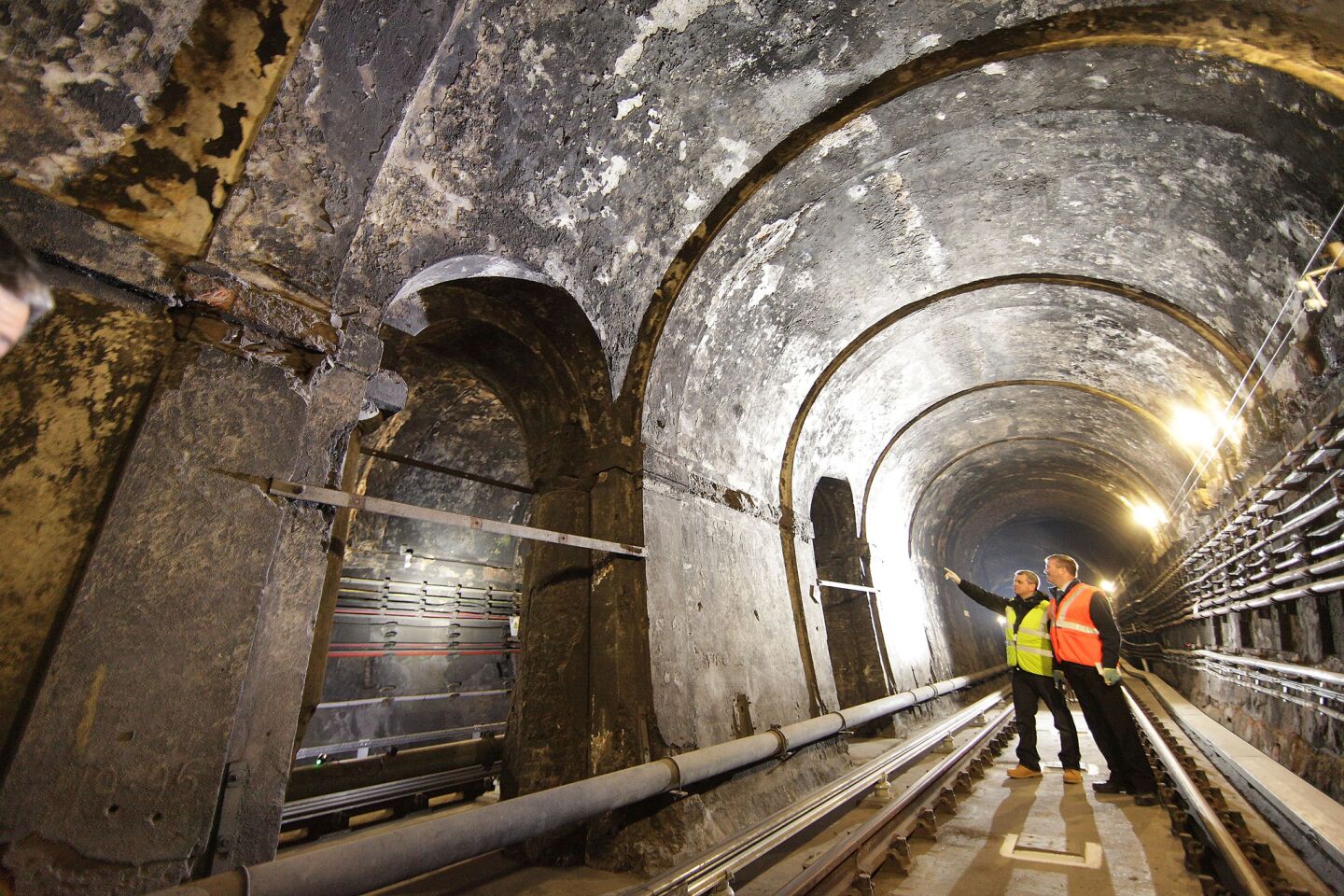 Railway workers look at original brickwork in the Thames Tunnel.