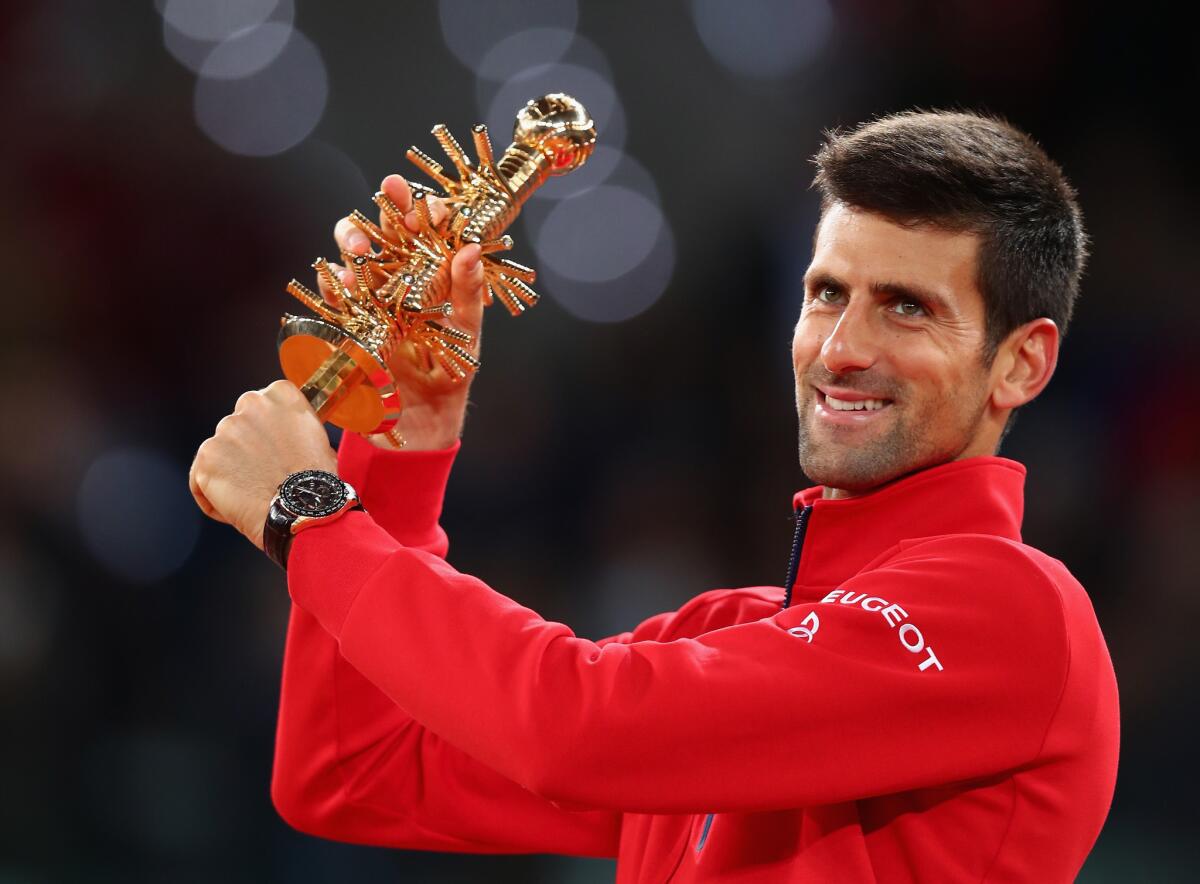 Novak Djokovic of Serbia lofts the Madrid Open trophy after defeating Andy Murray in the final on Sunday.