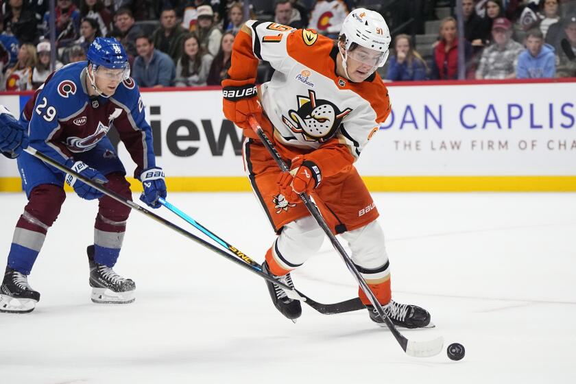 Anaheim Ducks center Leo Carlsson, right, drives with the puck past Colorado Avalanche.