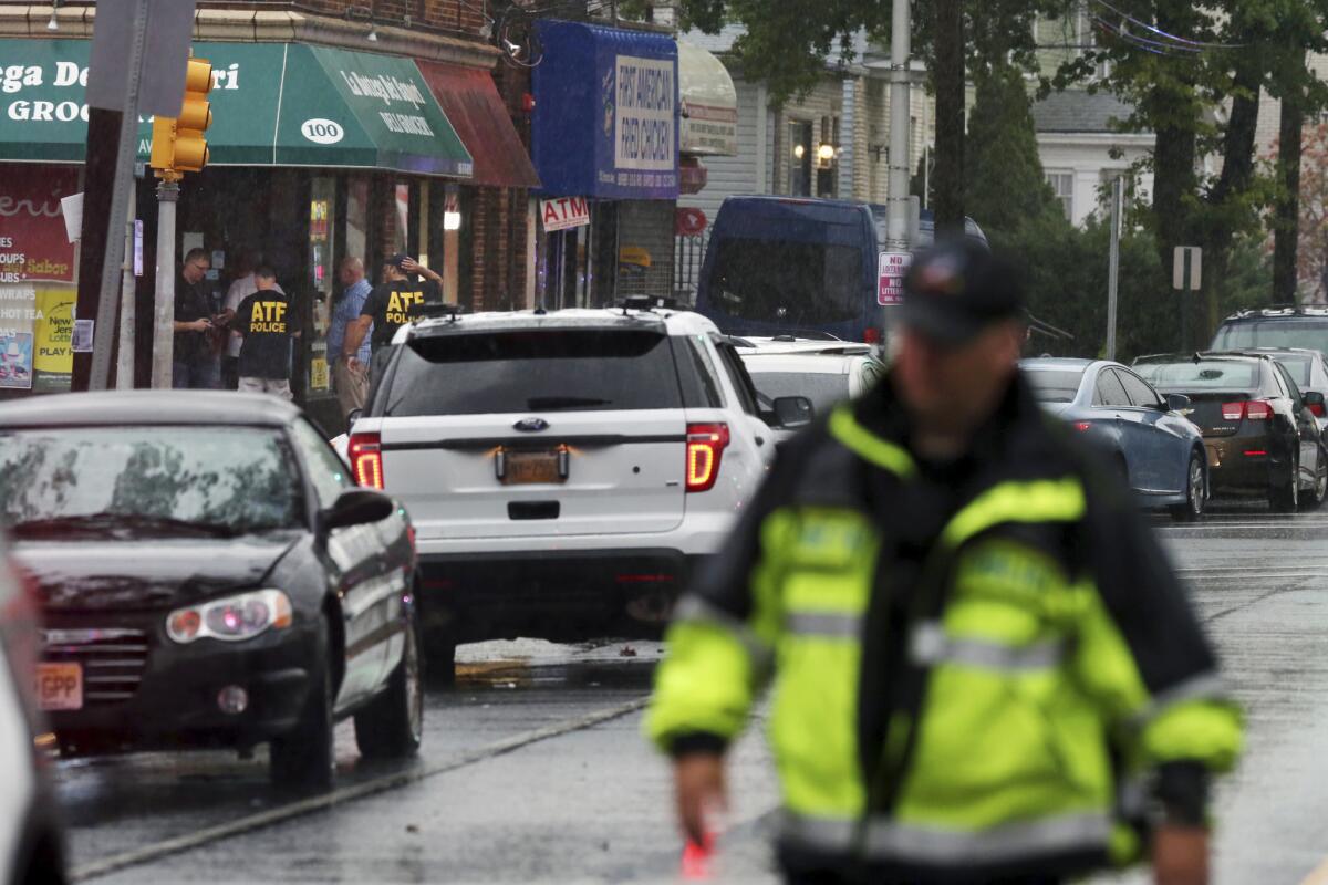 Varios policía y funcionarios se reunen en la entrada de un edificio en la avenida Elmora la mañana del lunes 19 de septiembre de 2016, en Elizabeth, New Jersey. Un dispositivo sospechoso encontrado en un cesto de basura cerca de una estación de tren de New Jersey estalló el lunes de madrugada cuando un equipo de artificieros intentaba desactivarlo con un robot, según las autoridades. (AP Foto/Mel Evans)