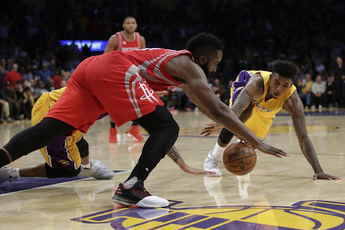 Lakers guard Nick Young and Rockets guard James Harden dive for a loose ball lare in the fourth quarter.
