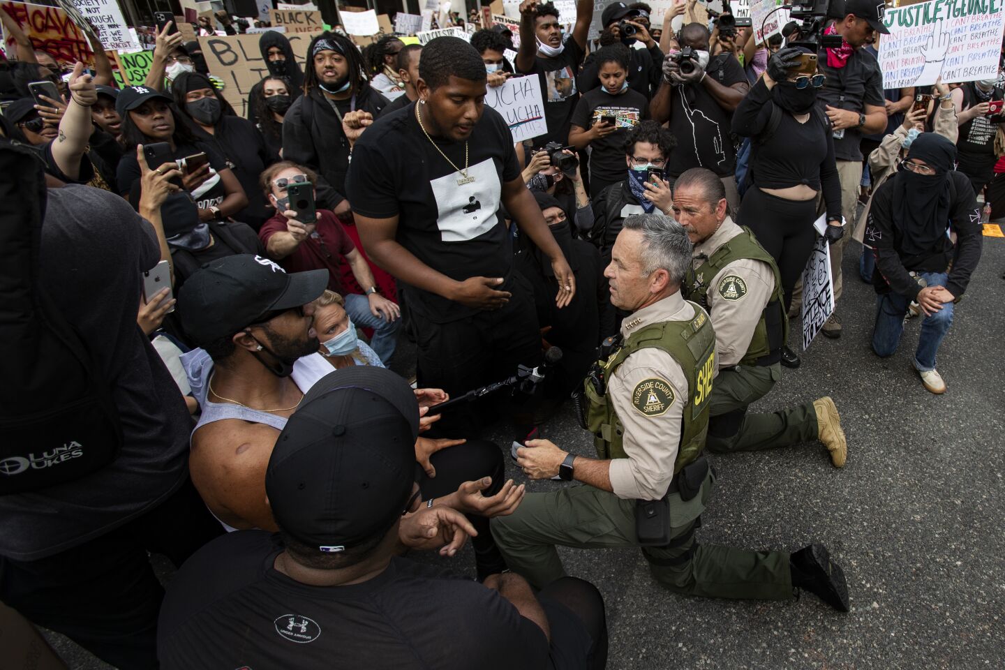 Riverside County Sheriff Chad Bianco takes a knee with demonstrators.