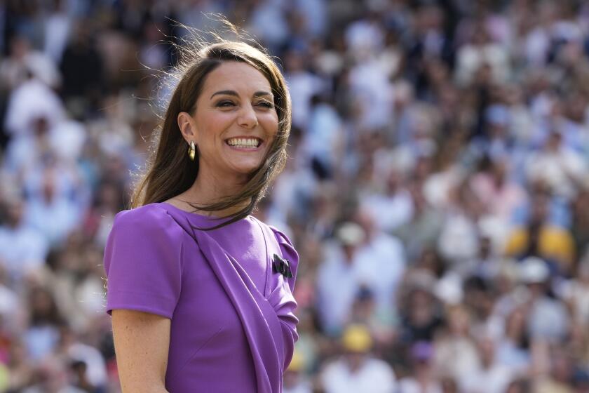 ARCHIVO - Kate, la princesa de Gales, espera para entregar el trofeo a Carlos Alcaraz de España después de que derrotó a Novak Djokovic de Serbia en la final individual masculina del campeonato de tenis de Wimbledon en Londres, el 14 de julio de 2024. (Foto AP/Kirsty Wigglesworth, archivo)