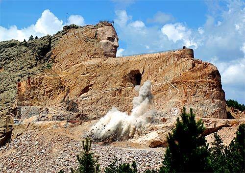 An afternoon blast shaves 300 tons off the Crazy Horse Memorial near Mt. Rushmore in the Black Hills of South Dakota. When completed, the sculpture will show the Sioux warrior on horseback, pointing southeast to the lands where many of his people lie buried. "I just can't conceive the engineering that's going into this," one visitor said, gazing up from the base of the mountain.