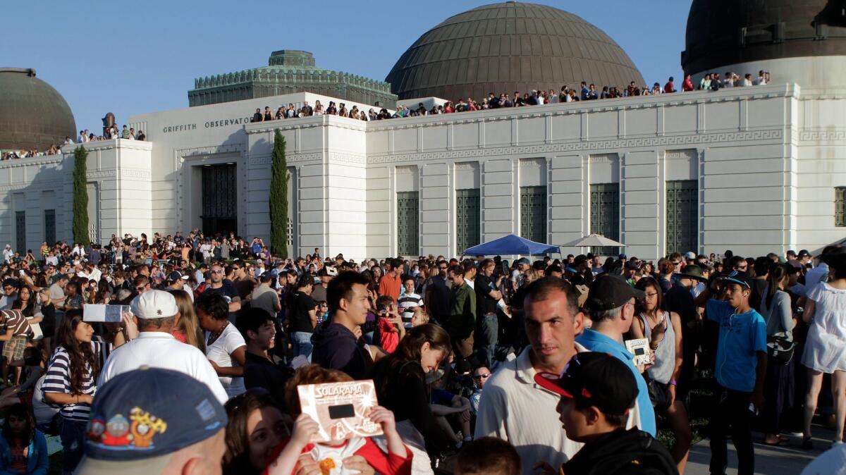 A partial solar eclipse in 2012 drew an enthusiastic crowd to the Griffith observatory. (Lawrence K. Ho / Los Angeles Times)