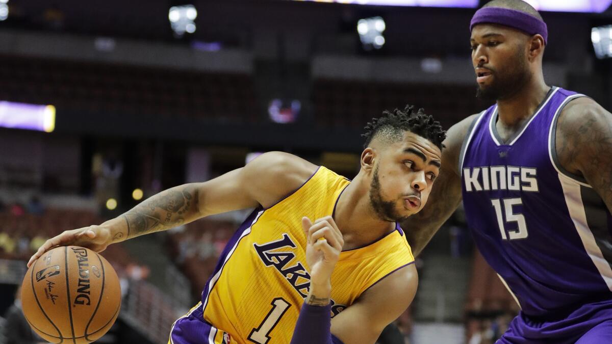 Lakers point guard D'Angelo Russell drives against Kings center DeMarcus Cousins during a preseason game Tuesday.