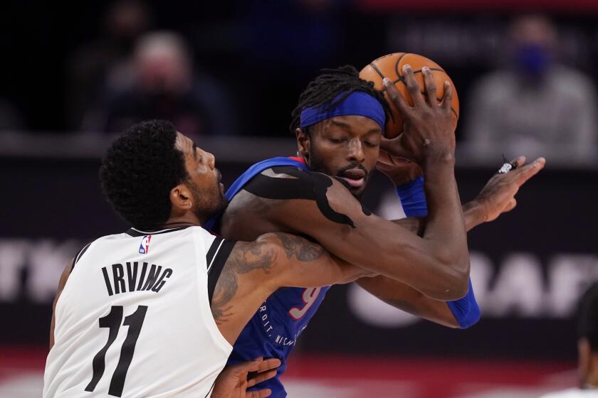 Brooklyn Nets guard Kyrie Irving (11) reaches in on Detroit Pistons forward Jerami Grant during the second half of an NBA basketball game, Tuesday, Feb. 9, 2021, in Detroit. (AP Photo/Carlos Osorio)