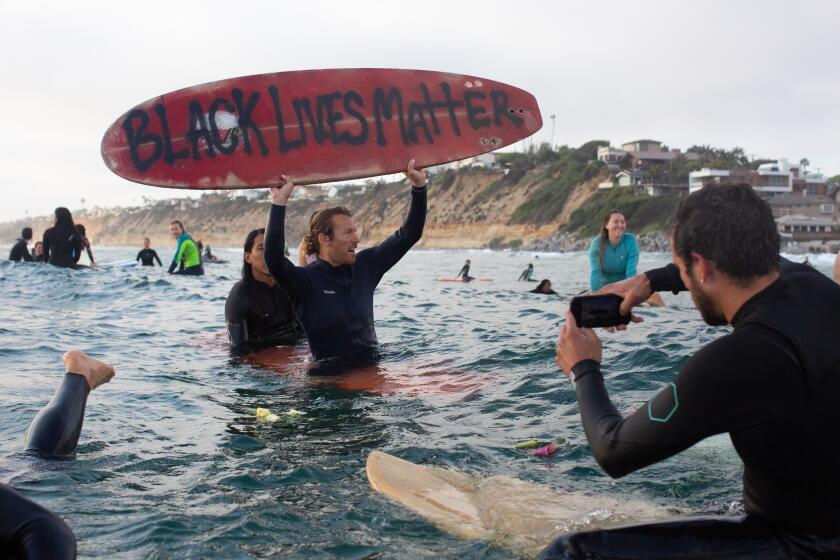 ENCINITAS, CA - JUNE 03: Protesters chant Black Lives Matter during a paddle out in solidarity with other national demonstrations showing outrage over the death of George Floyd in Moonlight State Beach on Wednesday, June 3, 2020 in Encinitas, CA. In surfing culture, paddle outs are held as a way to memorialize those who have lost their lives, or momentarily reflect on a time or issue. (Gabriella Angotti-Jones / Los Angeles Times)