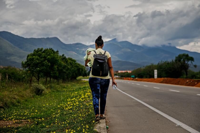 ##FOR CAMINANTES PROJECT WITH ANDREA CASTILLO, DO NOT PUBLISH UNLESS CONTACT MARY COONEY FOR PERMISSION## At the beginning of her journey, Valentina Durán carries her month-old son, Samuel and walks along Route 55 near Cúcuta, Colombia, on May 6, 2019. Each day an estimate of 5000 people flee Venezuela. They simply walk out. The departure of the caminantes, or walkers, began slowly in 2017 with young men hoping to find jobs and send money home. By this year, women and children, the sick and the elderly had also decided to take their chances, expanding an exodus that already is one of the biggest mass migrations in modern history. (Marcus Yam / Los Angeles Times)