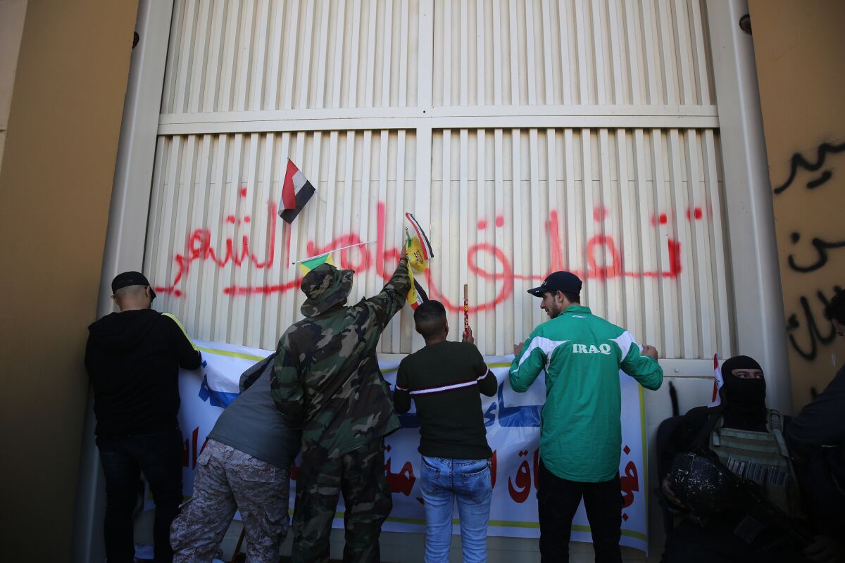 Iraqi protesters hang banners outside the U.S. Embassy in Baghdad after breaching its outer wall Dec. 31.