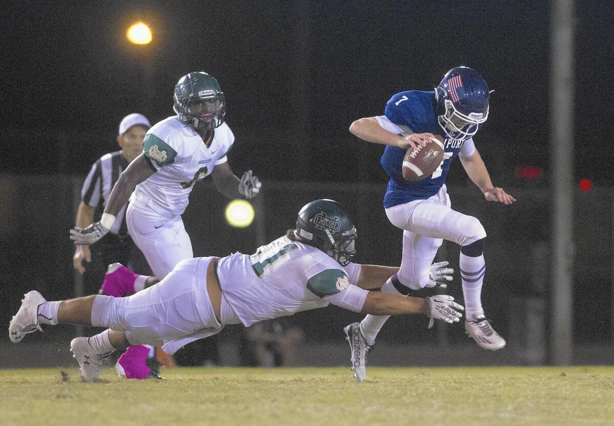 NEWPORT BEACH, CA, October 2, 2015 -- Newport Harbor High quarterback Michael Bonds evades a Mira Costa tackle during the first half in a nonleague game at Davidson Field on Friday. (Kevin Chang/ Daily Pilot)