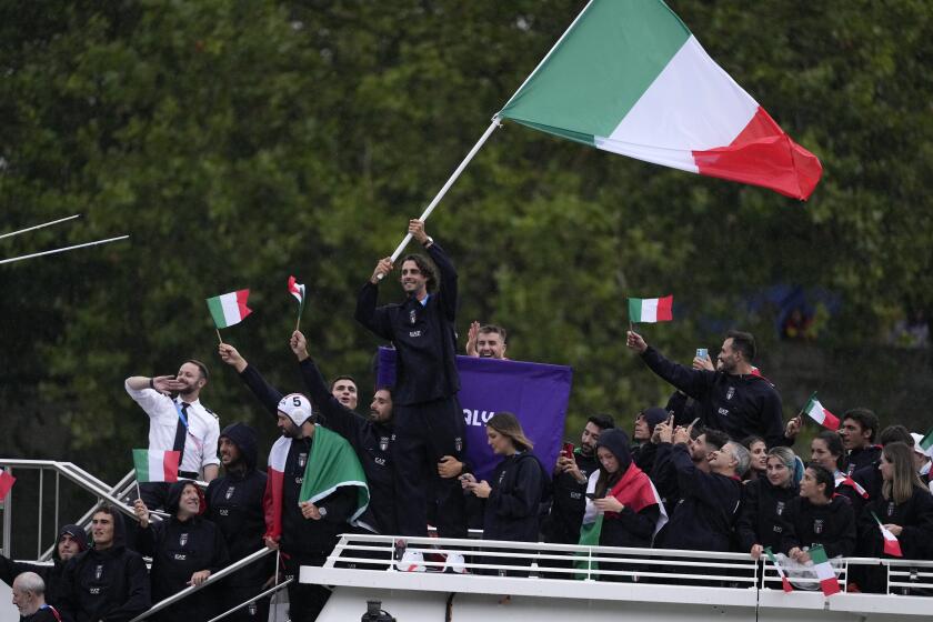 El italiano Gianmarco Tamberi agita la bandera del país durante la ceremonia inaugural de los Juegos Olímpicos de París, el viernes 26 de julio de 2024. (AP Foto/Luca Bruno)