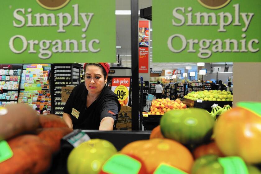 Southern California’s $44 billion in annual grocery sales makes it the largest U.S. grocery market by far. Above, produce clerk Veronica Padilla stocks apples at the Ralphs grocery store in downtown Los Angeles.