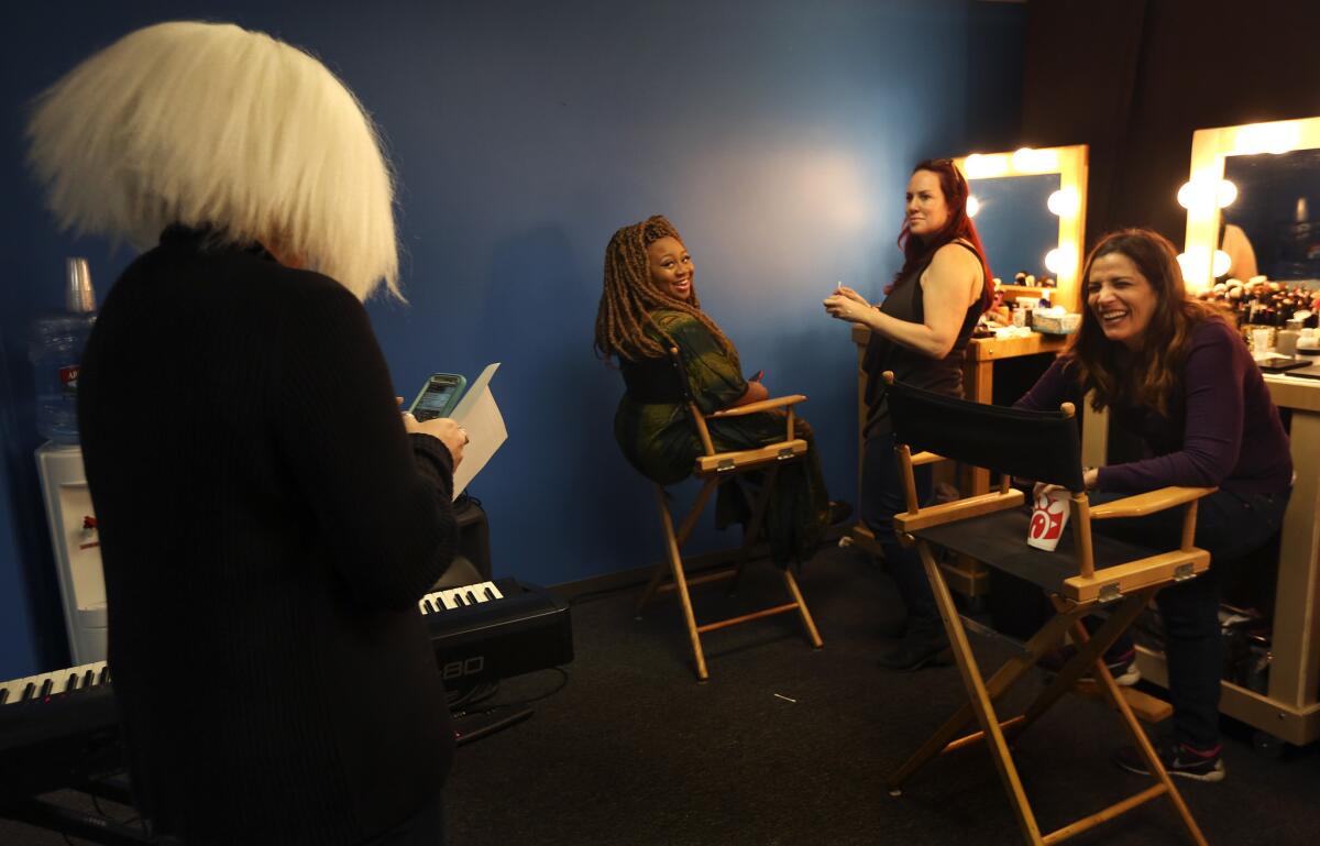 "American Idol" contestant La'Porsha Renae, second from left, reacts to associate producer Kate Tucci's wig, similar to the kind that singer-songwriter Sia wears. Renae was getting her makeup done by Jo Jo McCarthy, third from left, before the start of a dress rehearsal.