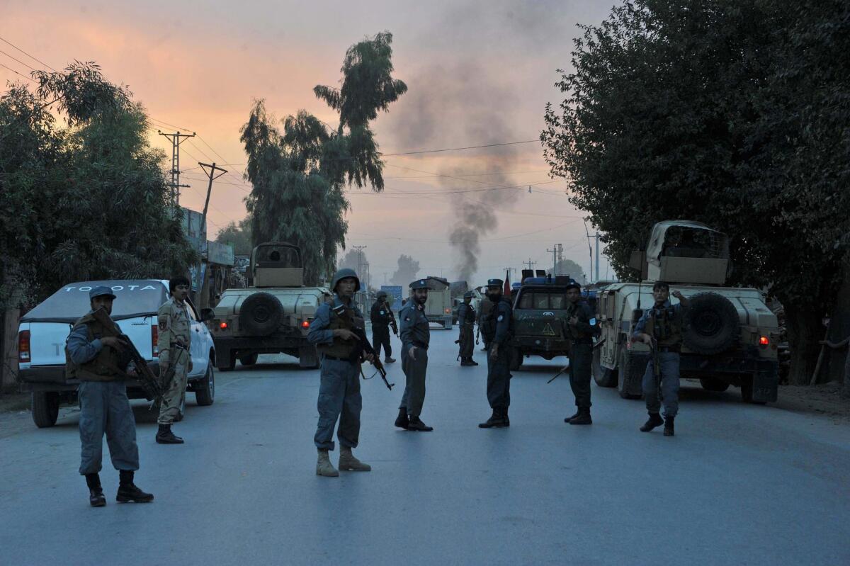 Afghan policemen keep watch as after an attack by Taliban militants on the intelligence service office in Jalalabad.