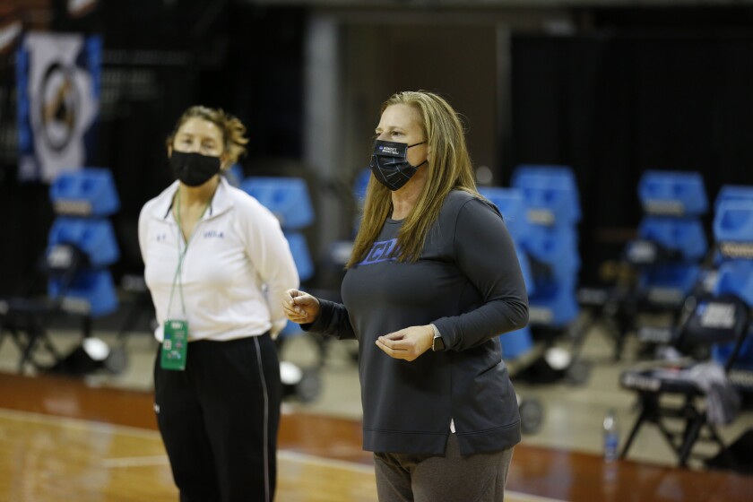 UCLA's Cori Close wears a mask as she coaches basketball practice.