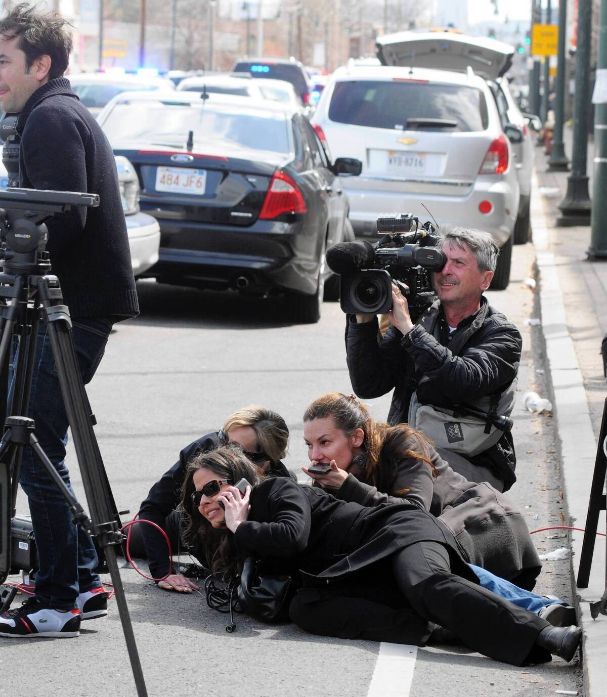 Journalists take cover during the manhunt for the second suspect of the Boston Marathon bombing in Watertown, Mass. Some traditional media got caught up in the frenzy of online speculation used incorrect information from anonymous posters.