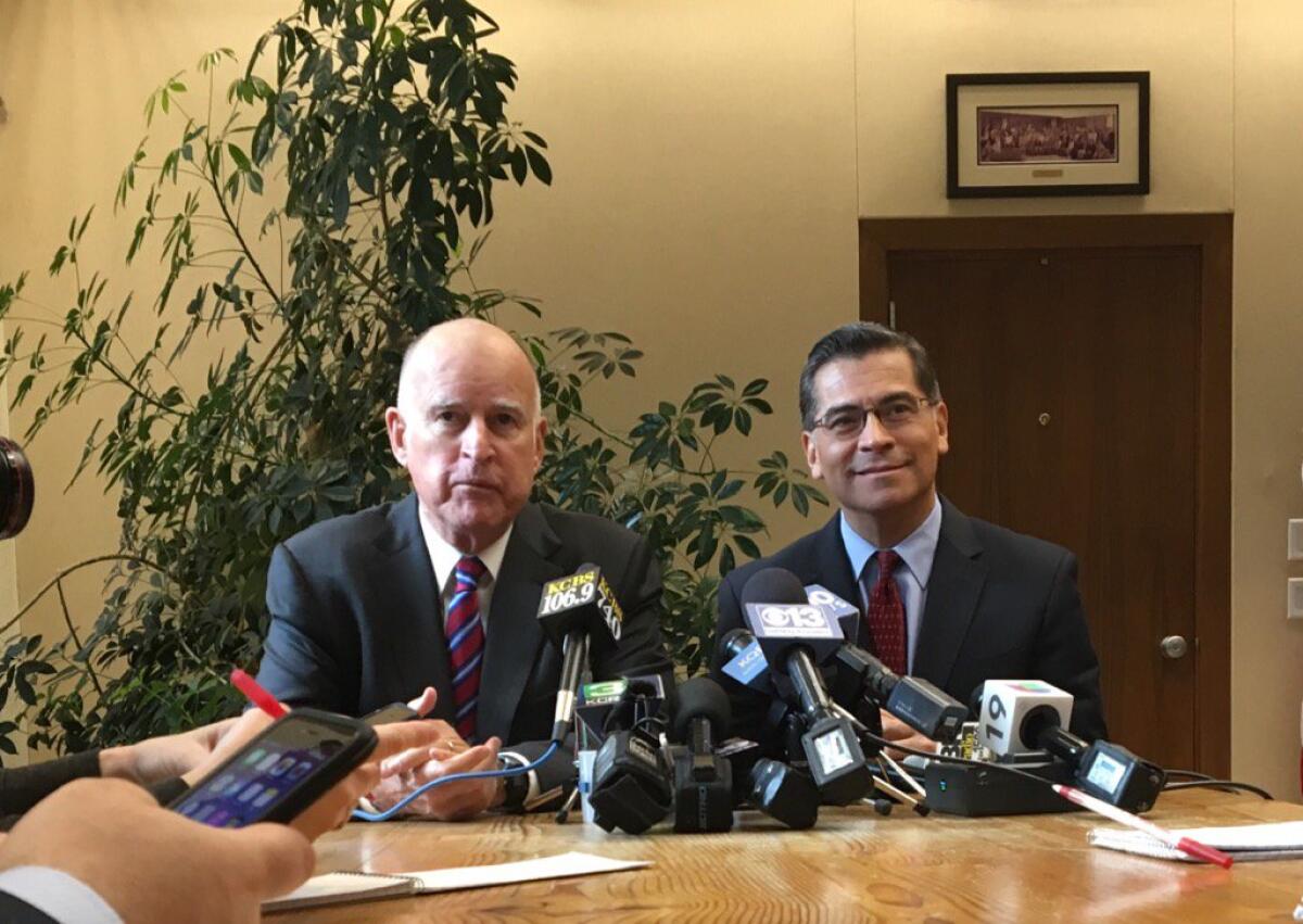 Gov. Jerry Brown and Rep. Xavier Becerra (D-Los Angeles) speaking to reporters in Sacramento.
