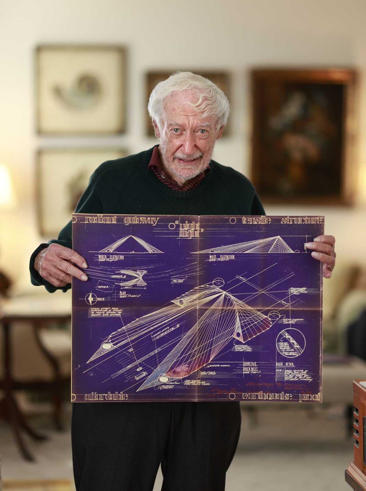 Architect Eugene Ray holds a plan for his Radiant Gateway design, a fiber optic overpass.