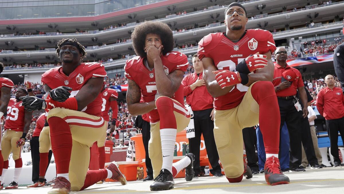San Francisco 49ers linebacker Eli Harold, left, quarterback Colin Kaepernick and safety Eric Reid kneel during the national anthem before a game against the Cowboys on Oct. 2, 2016.