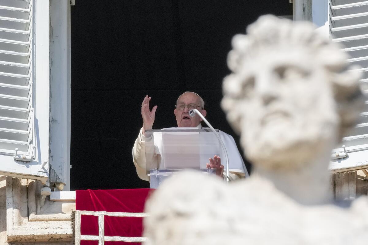 El papa Francisco ofrece su bendición mientras recita el Angelus desde la ventana de su estudio