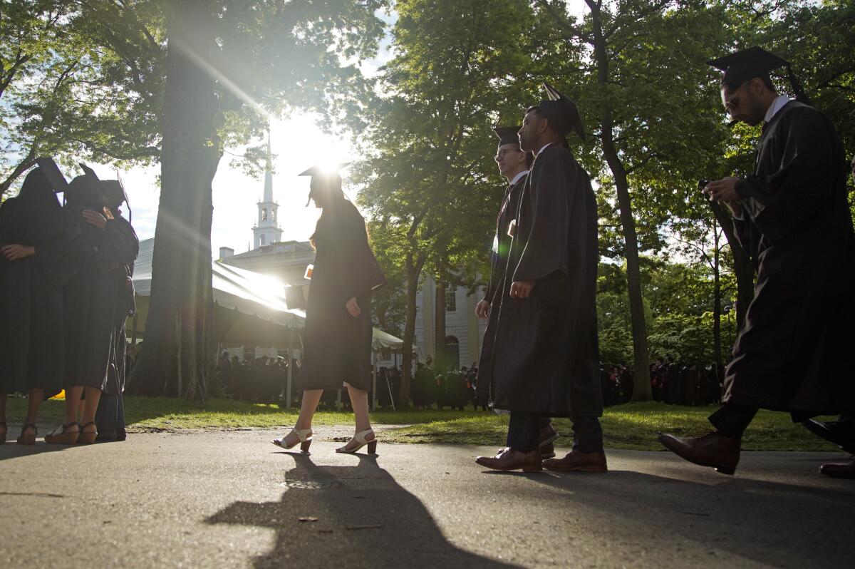 Graduates walking at a Harvard commencement ceremony 