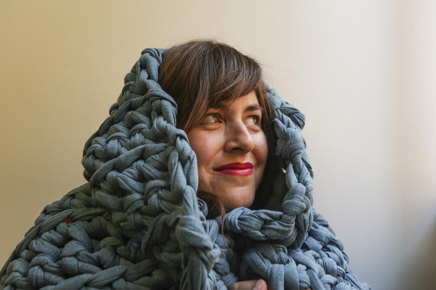 Pamela Hunter, founder of Sheltered Co., in one of their blue weighted blankets.