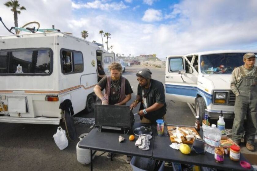 Residents of the white and blue Econoline van, left, prepare a breakfast of donated food on a butane range. Their street names, from left, Noodle, Oak and Noah.