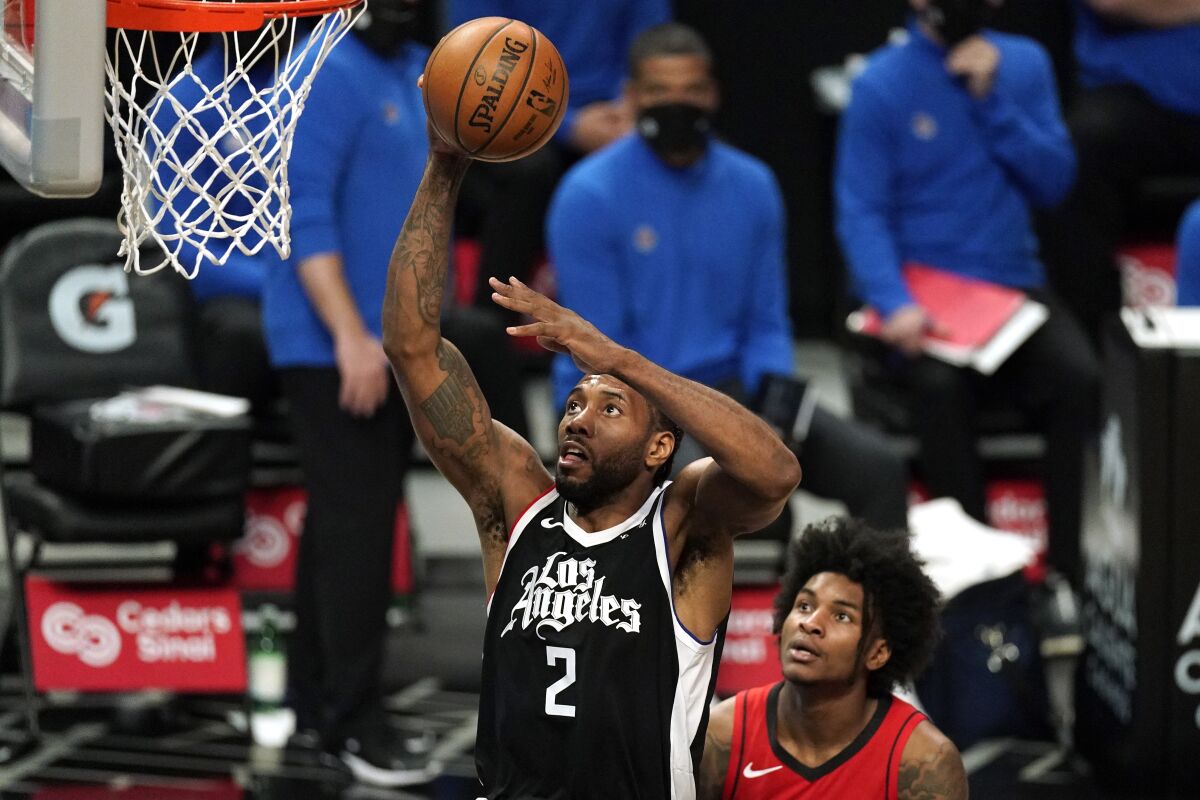 Los Angeles Clippers forward Kawhi Leonard, left, shoots as Houston Rockets guard Kevin Porter Jr. watches during the first half of an NBA basketball game Friday, April 9, 2021, in Los Angeles. (AP Photo/Mark J. Terrill)