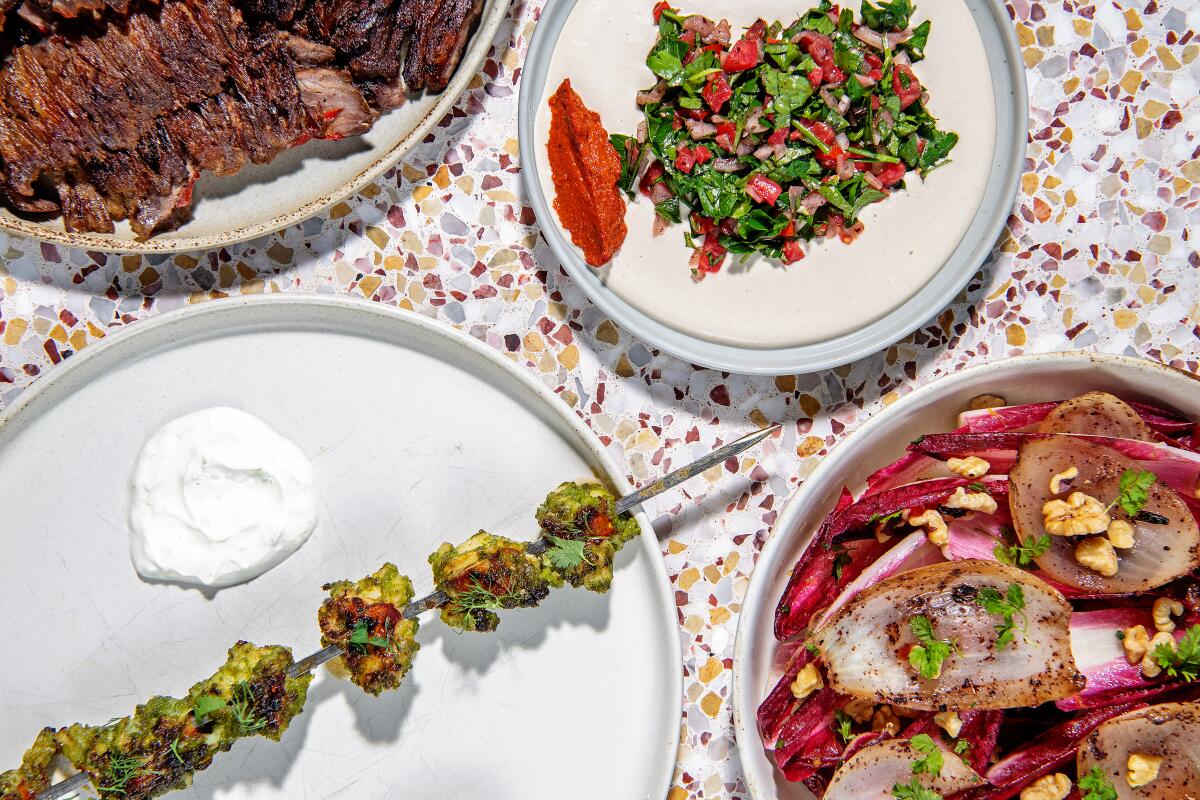 LOS ANGELES, CA - OCTOBER 14: clockwise from bottom left: Lobster skewer, shawarma plate and the grilled onion and endive salad from Saffy's on Friday, Oct. 14, 2022 in Los Angeles, CA.(Mariah Tauger / Los Angeles Times)