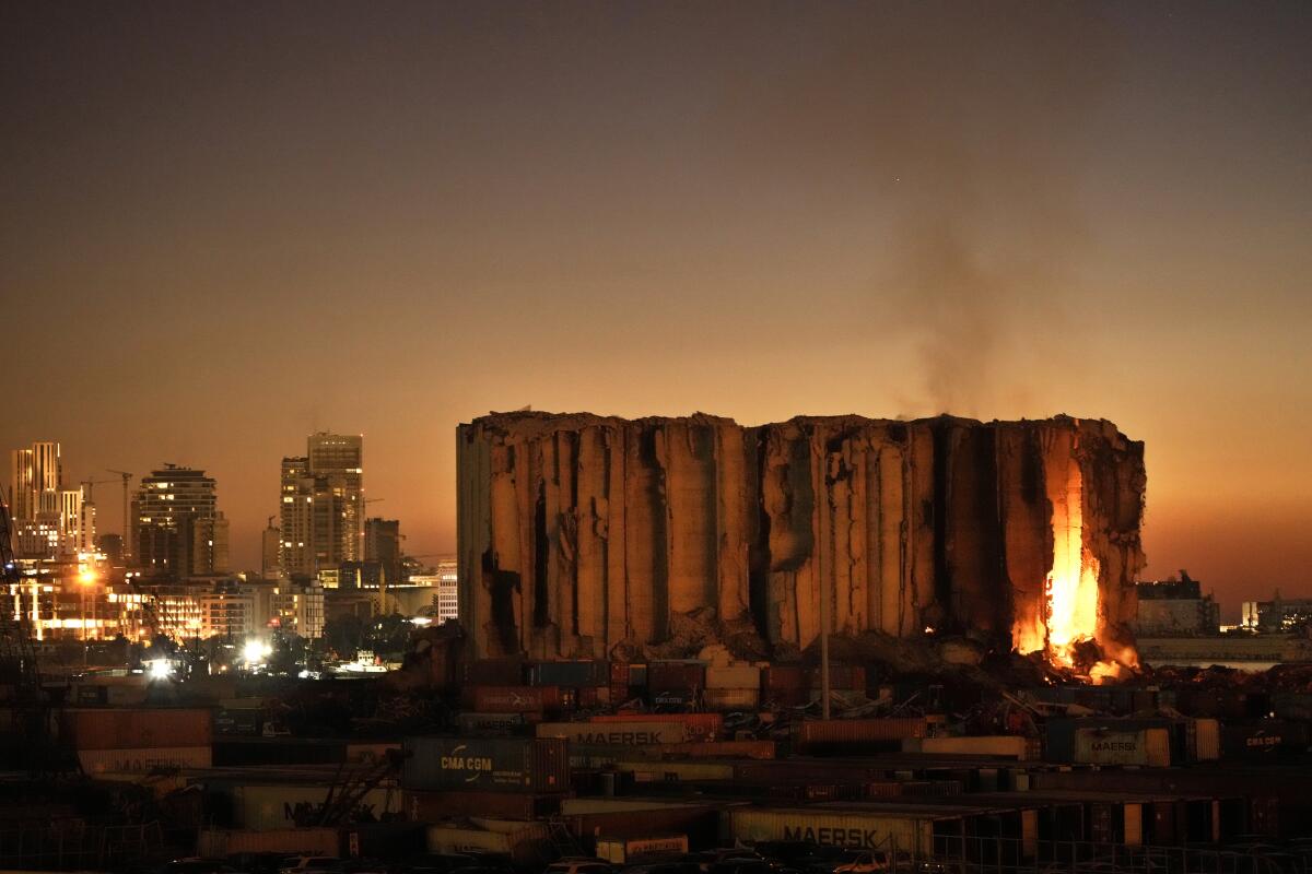 FILE - Silos in the north block of the Beirut Port, that were destroyed by a massive explosion in 2020, have caught fire due to fermented grains in Beirut, Lebanon, Sunday, July 24, 2022. It has been two years since a warehouse full of ammonium nitrate at Beirut's port exploded, destroying large parts of the city, killing more than 215 people and injuring thousands. Many families are losing hope of ever finding justice. (AP Photo/Hassan Ammar, File)