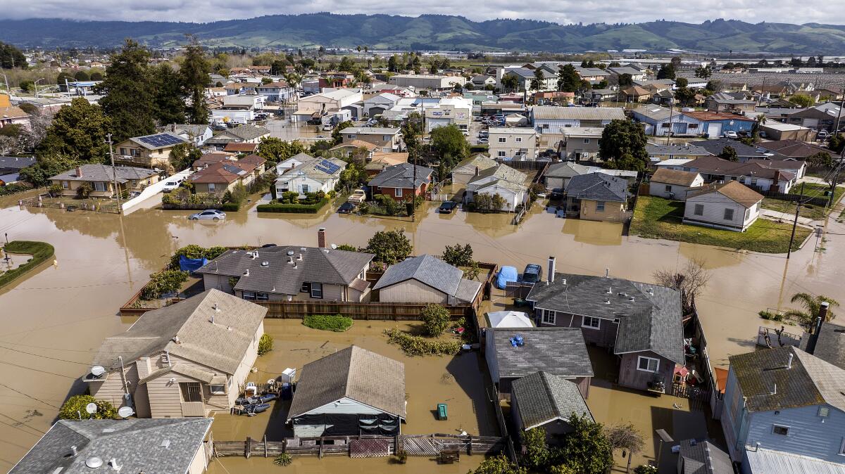 Floodwaters surround homes and vehicles in Monterey County, Calif.