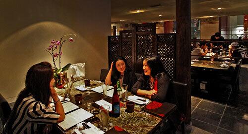 Diners in the semi-private booth of Bann Restaurant, a new Korean restaurant with striking design details.