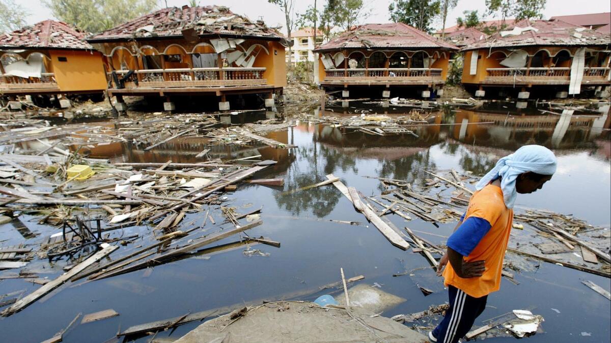 A man looks out at the remains of a hotel resort in Khao Lak in Thailand's Phang Nga province on Jan. 9, 2005, after the 2004 Indian Ocean tsunami.
