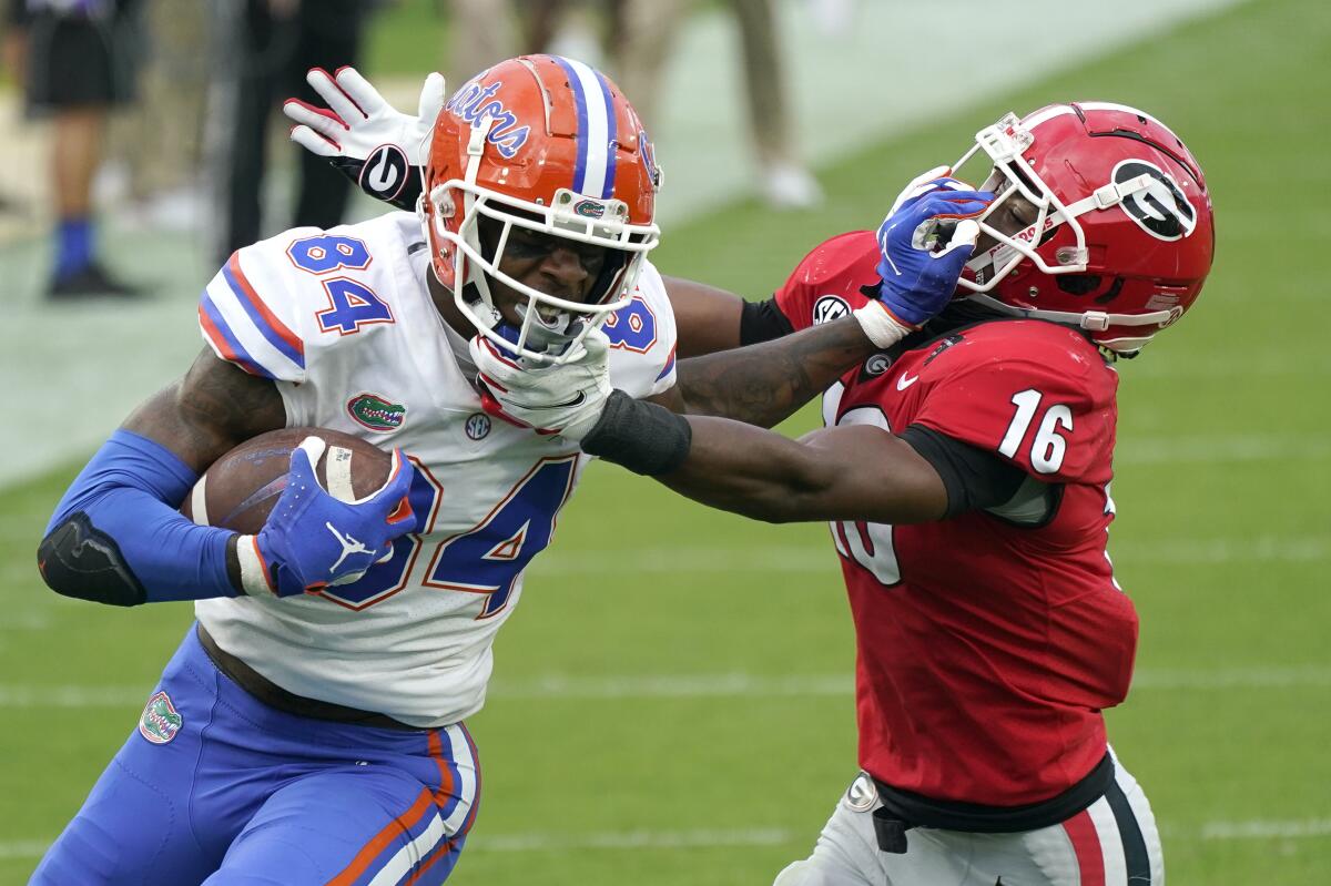 Florida tight end Kyle Pitts (84) tries to get past Georgia defensive back Lewis Cine (16) after a catch Nov. 7, 2020.