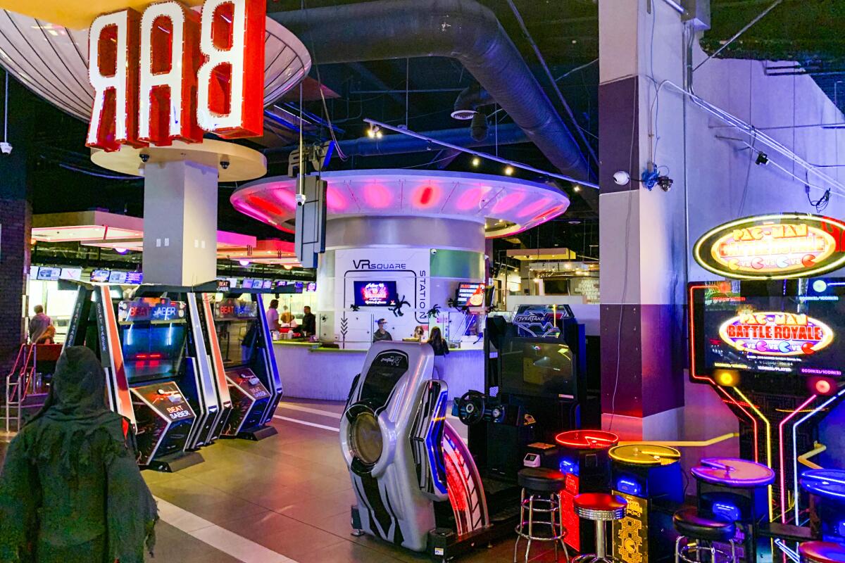 Arcade games fill a large room with a bar in the back