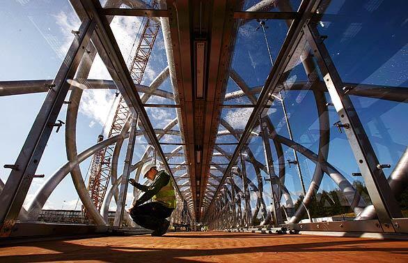 A worker makes final preparations to lift a new footbridge into place between junction four and five on the M8 motorway in Harthill, Scotland. Scotland's busiest motorway will be closed tonight while the largest crane in Britain is used to install the new footbridge.