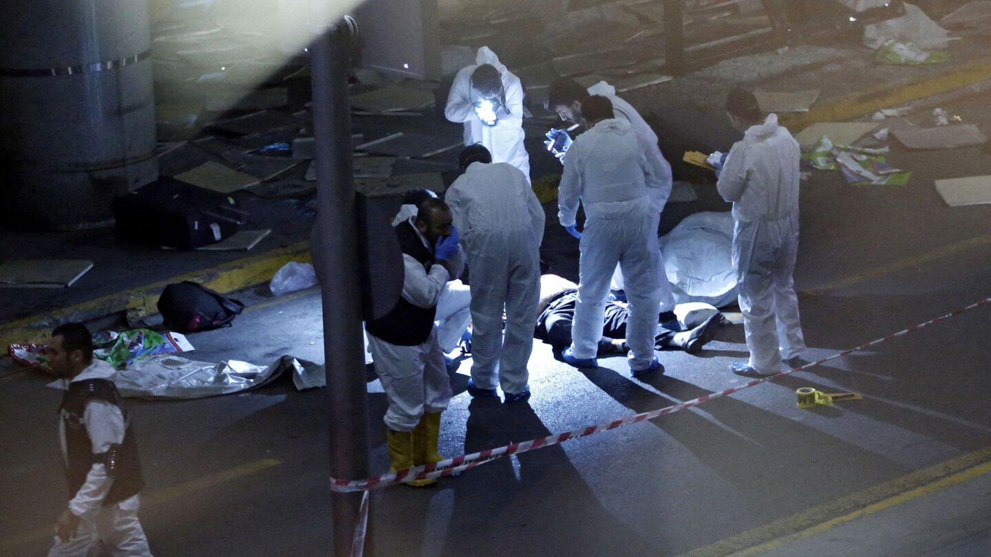 Crime scene investigators work next to a victim killed in the boming at Ataturk Airport in Istanbul.