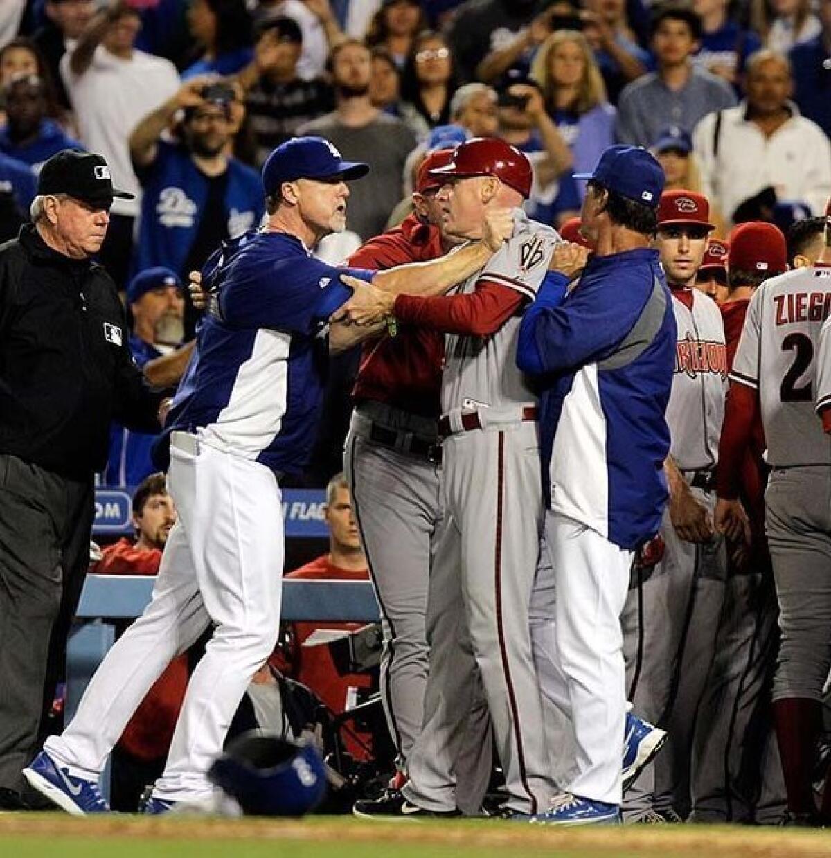 Dodgers hitting coach Mark McGwire, left, grabs Arizona coach Matt Williams after the Diamondbacks' Ian Kennedy hit Zack Greinke with a pitch.