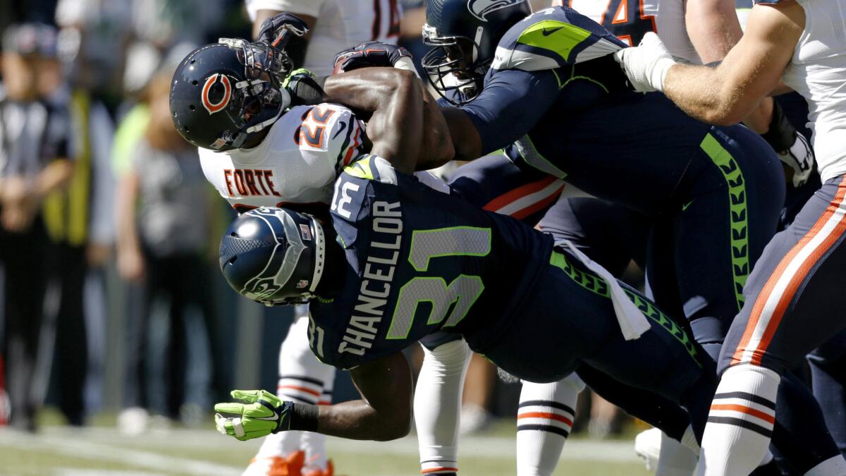 Seahawks safety Kam Chancellor and defensive tackle Ahtyba Rubi tackle Bears running back Matt Forte in the first half Sunday in Seattle.