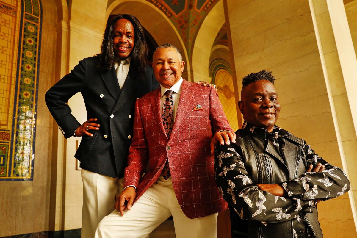 The members of Earth, Wind & Fire standing in stair-step formation