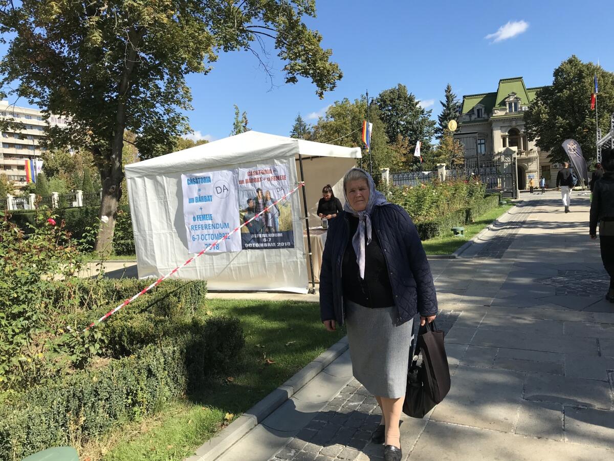 A woman walks by an information tent set up outside the Metropolitan Cathedral in Iasi, Romania, in support of an Oct. 6 referendum on changing Romania's constitution to define marriage as a union between a man and a woman.