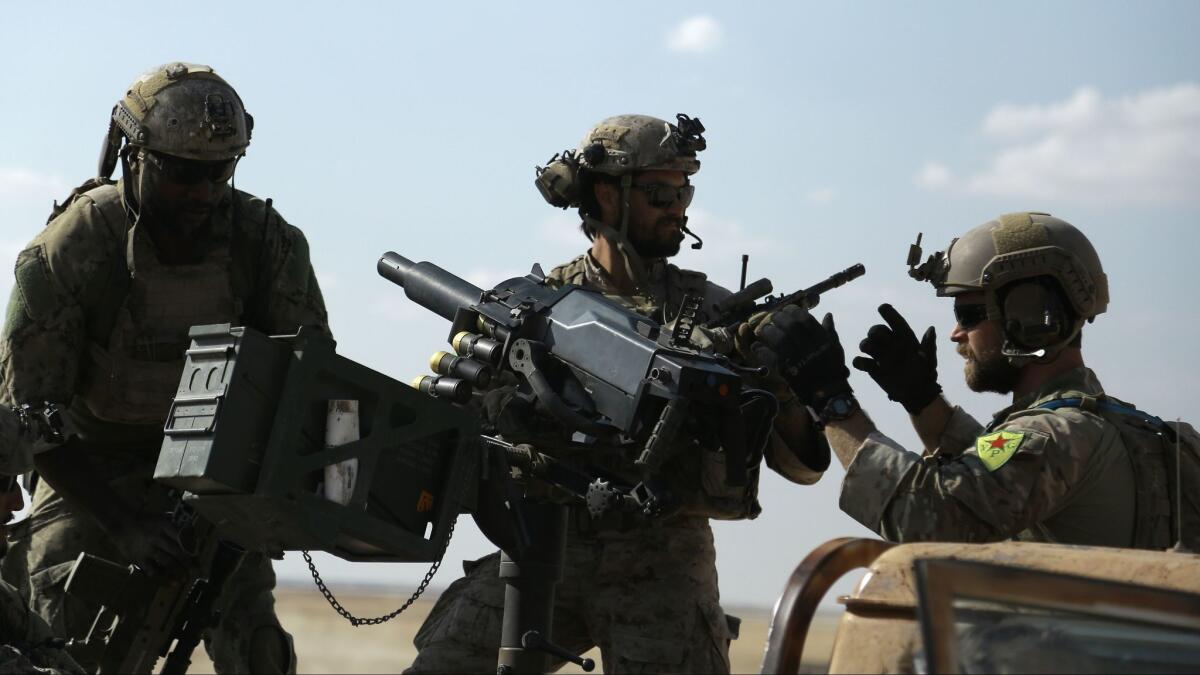 Men in uniform identified by Syrian Democratic forces as US special operations forces ride in the back of a pickup truck in the village of Fatisah in the northern Syrian province of Raqa on May 25, 2016.